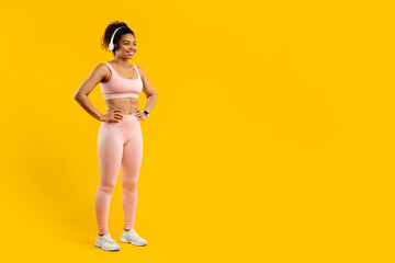 Fit woman in activewear on yellow background