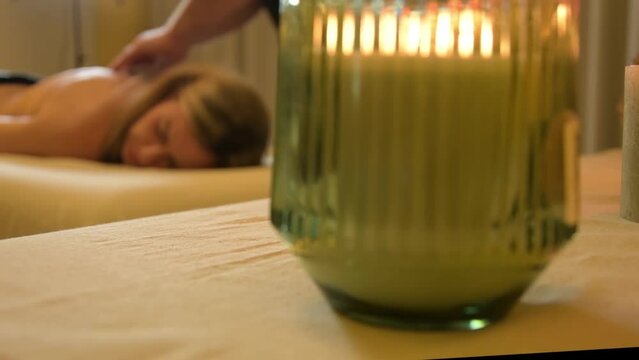 A middle-aged woman gets a back massage at a spa. 