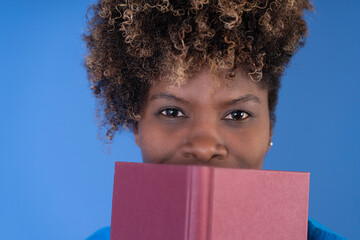 Woman Holding Pink Book Over Face