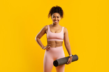 Fitness lady holding yoga mat and smiling