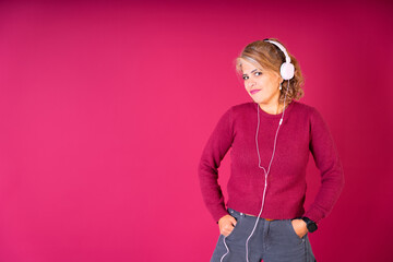 Woman Wearing Headphones in Front of Pink Background