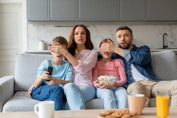 Family watching a shocking scene on the TV