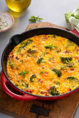 Healthy frittata or quiche with broccoli and red pepper whole in a cast iron pan