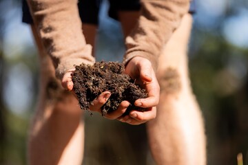 farmer holding soil in hand and pouring soil on ground. connected to the land and environment. soil agronomy in australia. soil heath study - obrazy, fototapety, plakaty