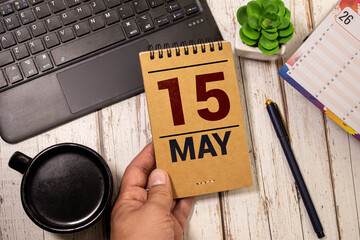 May 15 calendar date text on wooden blocks with blurred nature background.