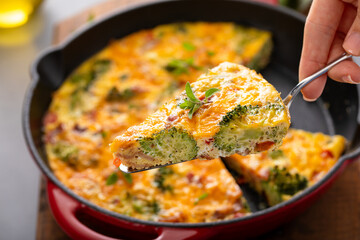 Healthy frittata or quiche with broccoli and red pepper cooked in a cast iron pan