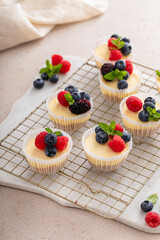 Mini vanilla cheesecakes cooked in a muffin pan served with fresh berries