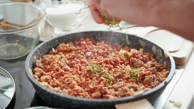 Cooking bolognese sauce in a frying pan on the stove in the kitchen, stock footage video 4k