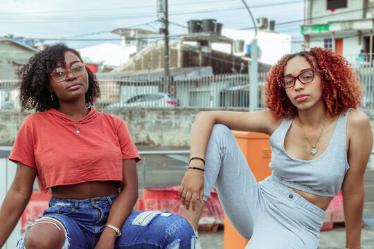 Amigas de cabello afro rizado usan gafas y ropas de estilo urbano