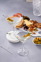 Traditional martini cocktail with olive garnish and charcuterie board