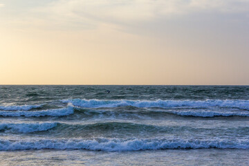 Obraz premium Little waves sliding toward the beach indicating persistence, peace and tranquility with copy space. 