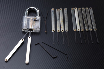 Clear Lock device over black background to show mechanic inside lock. Many lock pick tool to unlock key of door window vehicle for thief lockpick burglar.