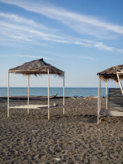 Abandoned decorative houses with thatched roofs on the seashore. Off-season. Lack of tourists.