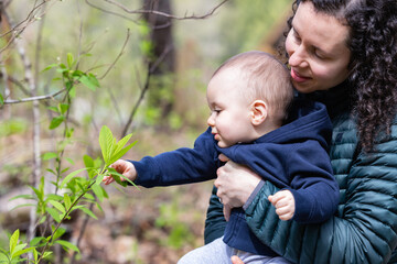 Caucasian Baby Boy and Mother in Forest playing with branches and trees.