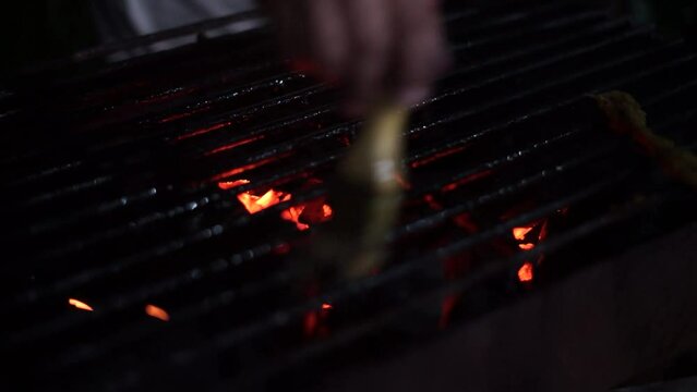 a chicken ready to be grilled in a grill with charcoal embers