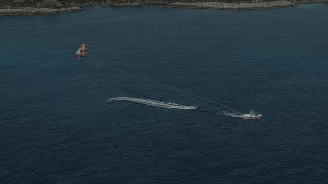 Panning shot with motorboats and parasail - drone shot