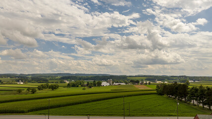 Fototapeta na wymiar Expansive Farmland Under a Cloud-Adorned Sky