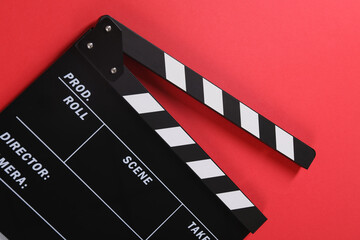 Fototapeta na wymiar Clapperboard on red background, top view. Film industry
