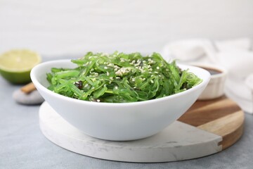 Tasty seaweed salad in bowl on gray table, closeup