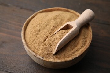 Dietary fiber. Psyllium husk powder in bowl and scoop on wooden table, closeup