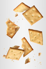 Tasty dry crackers falling on light grey background