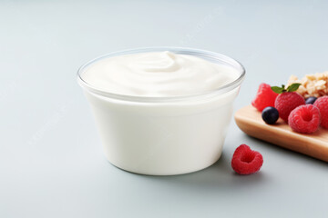 Plain yogurt or Greek yogurt in a bowl served with fresh raspberries