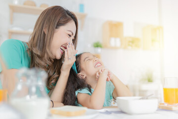 Asian children and her mom have a breakfast in the morning, child nutrition and development, they...