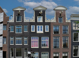 Traditional Amsterdam architecture buildings with brick wall facades and closed windows - 785798482