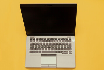 Modern open business laptop technology with blank black screen isolated on yellow background - 785798484