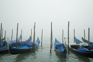 Gondolas tied to poles near San Marco square in Venice, Italy