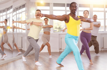 Group of multicultural men and women dancing jazz funk in studio