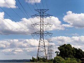 a row of hydro electric distribution towers near the water