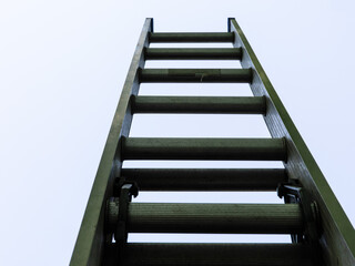 An aluminum extension ladder reaching up to the sky