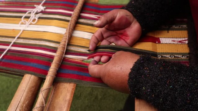 mujer peruana haciendo tejido tradicional de chinchero cusco peru