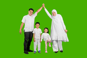 Happy Asian muslim family of four posing together isolated over green background