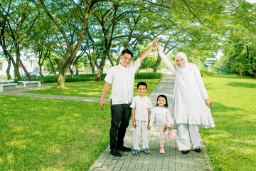 Happy Asian muslim family of four posing together
