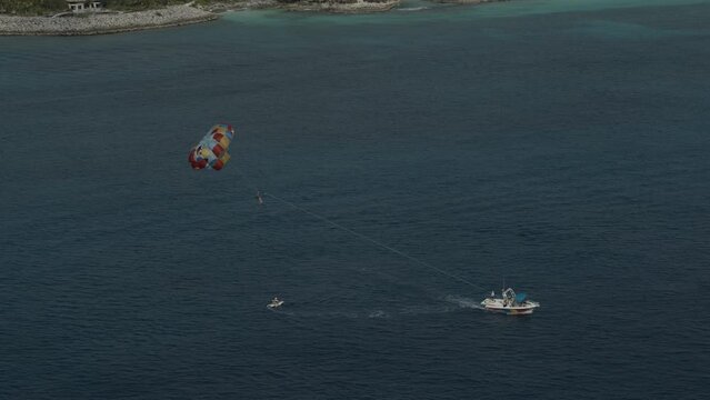Cinematic shot over parasail and motorboat in ocean