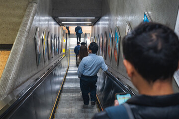 Commuters Riding Escalator in Busy Metro Station