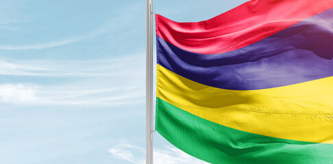Mauritius national flag with mast at light blue sky.