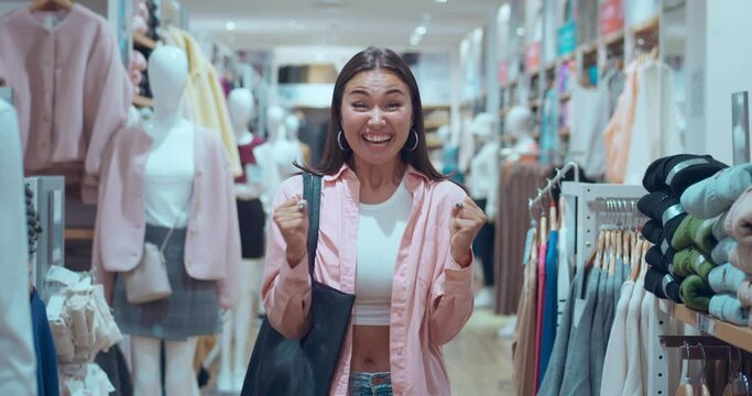 Woman's face full of happiness in clothing store smiling at camera Woman's happiness shines capturing essence joyful shopping. Woman's happiness symbol strong heartfelt emotions Expresses pure joy.