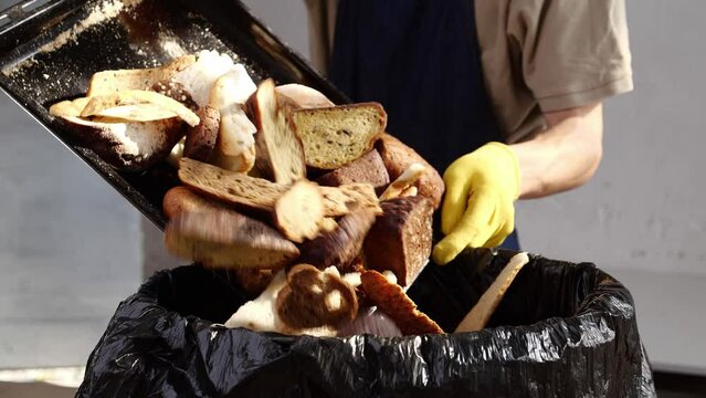 Baker throws unsold bread in the trash. Bakeries waste. Repurposing discarded dough