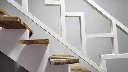 Picture of wooden textured stair of the house with white rail.