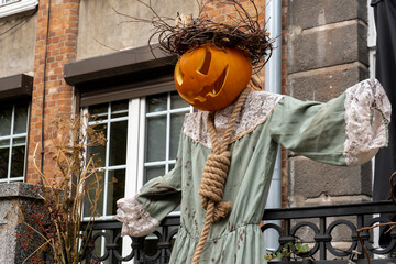 Exterior Beautiful atmospheric halloween scary scarecrow pumpkin decorated on porch. Autumn leaves...