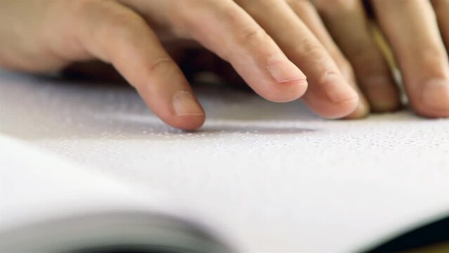 A Man Reading Braille Text with His Fingers. Close Up. 4K Resolution.