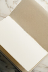 blank pages in accordion book on white marble surface