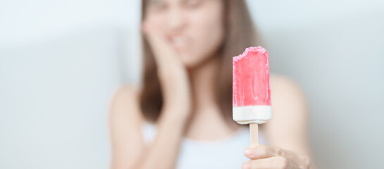 Teeth Sensitive to Cold concept. woman hold Ice cream and having toothache and pain after eat....