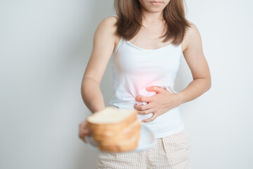 Gluten intolerance, Gluten free and celiac disease or wheat allergy concept. woman hold Bread and having abdominal pain after eat gluten. stomach ache, Nausea, Bloating, Gas, Diarrhea and Skin rash