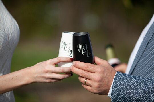 Newlyweds champagne toast, marriage celebration with bride and groom. Close up of flute glasses.