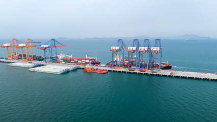 Crane loading box container to cargo ship at commercial dock port. Shipyard Cargo Container Sea Port Freight forwarding service logistics and transportation. International Shipping Depot Customs Port.