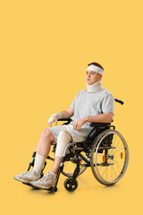 Obraz premium Injured young man after accident in wheelchair on yellow background